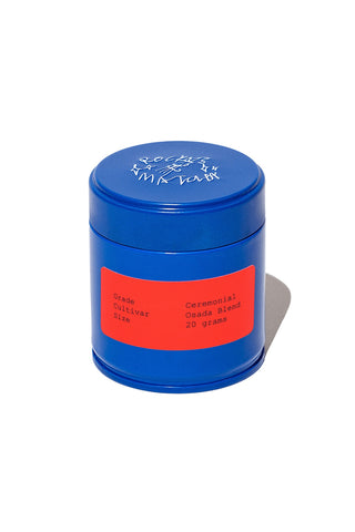 A blue tin of matcha powder with a bright red label reading 'Ceremonial Osada Blend 20 grams' on a white background.