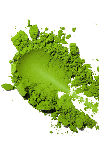 Green matcha tea powder on a white background