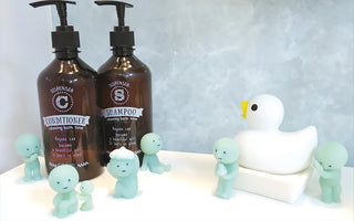 Small blue SMISKI bath figures with duck and bottles on a display
