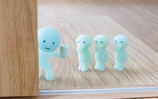 Set of four SMISKI blue mini toilet figurines standing on a wooden floor
