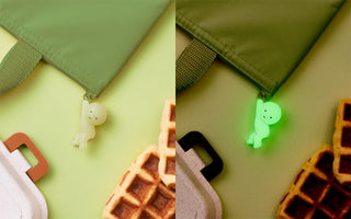 Glow-in-the-dark zipper charm figures on bag zipper pulls
