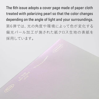Notebook cover made of paper cloth with polarizing pearl treatment, showing color change with light angle.