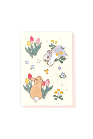 Greeting card with two cartoon bunnies and flowers on a light background