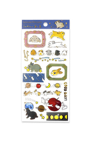 Sheet of decorative stickers with cartoon rabbits and space-themed designs on a white background.