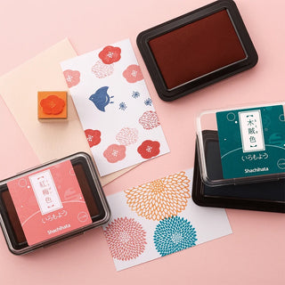 Colorful ink pads and stamped designs on a pink background
