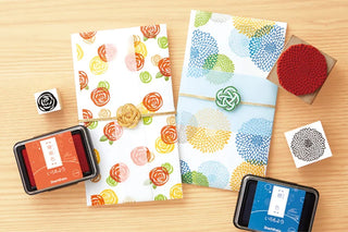 Two paper envelopes or wraps with floral pattern stamped with ink pads and stamps