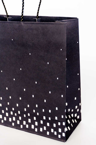 Black paper bag with white geometric pattern on a white background