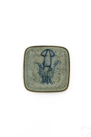 Square ceramic plate with blue squid design on a white background