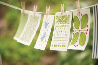 Environmentally friendly Swedish dishcloth with nature-themed design hanging on a line.