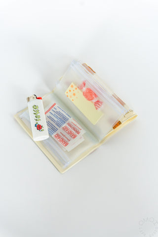 Opened brown bear pattern 5 pocket pouch with a lighter and items inside the pockets on a white background