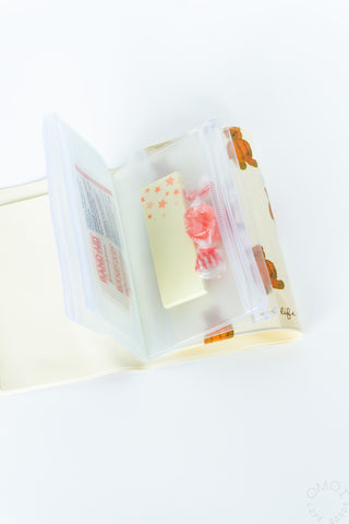 Close-up of brown bear pattern 5 pocket pouch with candy and sticky notes on a white background