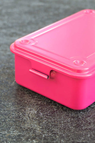 Pink toolbox with a lid on a dark textured surface