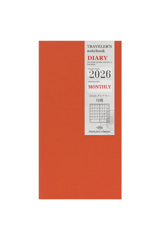 Orange notebook with 'Traveler's Diary' branding and 2026 monthly layout on a white background