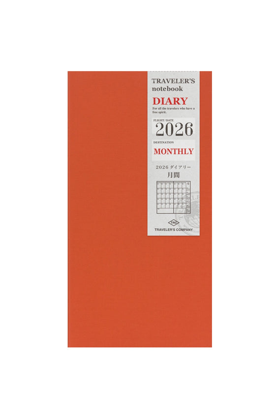 Orange notebook with 'Traveler's Diary' branding and 2026 monthly layout on a white background