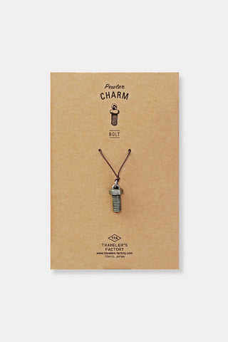 Notebook charm with a pendant on brown paper packaging featuring 'Traveler's Factory' branding.