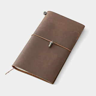 Brown leather notebook with a metal bolt charm on a white background