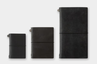 Three black leather notebooks of different sizes on a white background