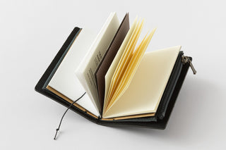 Open notebook with black leather cover on a white background