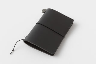 Black leather notebook with a strap on a white background