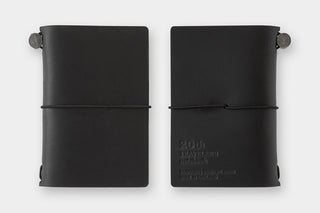 Two black leather-bound notebooks on a white background
