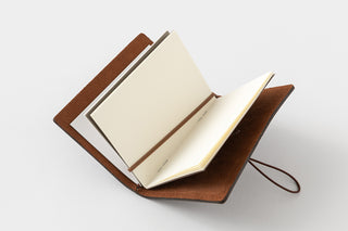 Open notebook with brown leather cover on a white background