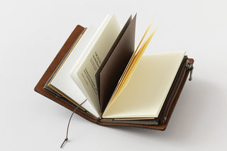Open leather-bound notebook on a white background