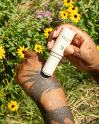 Talitha Koum HM+Barrier Multi Balm, white tube applying balm to arm