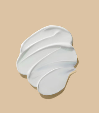 Dollop of thick white balm cream in soft, curved scoop shape