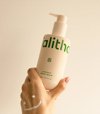 Body balm bottle held in hand, beige pump and green label visible