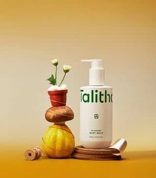 Body balm bottle on a wooden stand with small decorative items