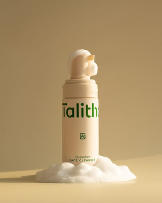 Beige face cleanser bottle dispensing white foam