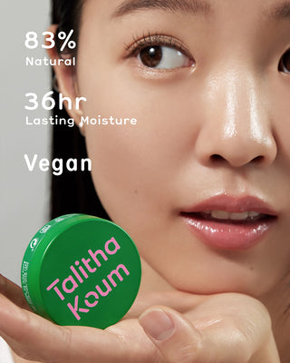 Talitha Koum Lipcure Balm jar near lips on smooth, moisturized skin