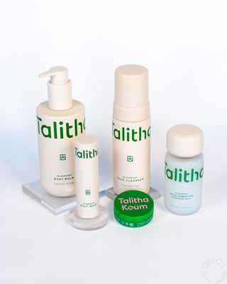 Talitha Koum lipcure balm tin with white skincare bottles and pump containers