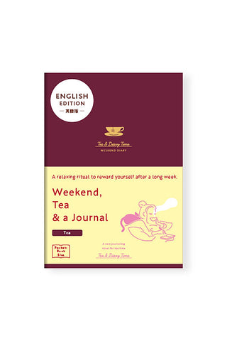 Burgundy journal that reads "Weekend, Tea & a journal" with an illustration of a person drinking coffee and writing with a cat nearby on its packaging