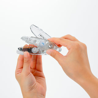 Hands holding a clear plastic tool against a white background