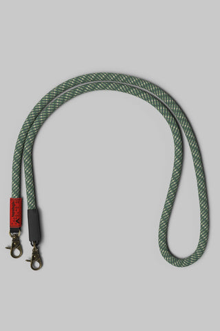 A dark green and pale green braided rope bag strap with bronze hardware displayed on a solid gray background.