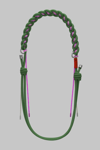 A green braided leather strap with pink accents and silver metal hardware, with a longer green strap on a solid gray background.