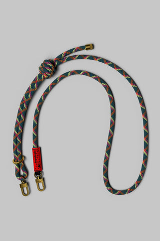 A braided rope leash with a knot, featuring a green, red, and orange pattern, hardware on a solid gray background.