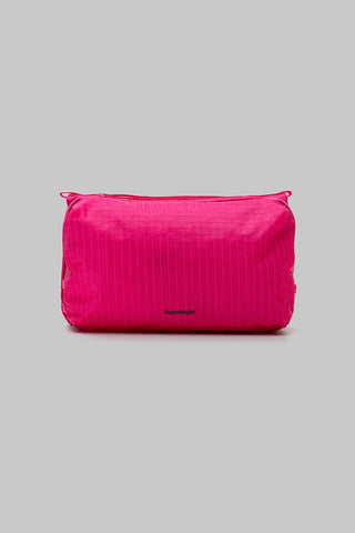 A bright pink bag with a subtle vertical texture and a small black 'topologie' logo near the bottom center, set against a solid gray background.