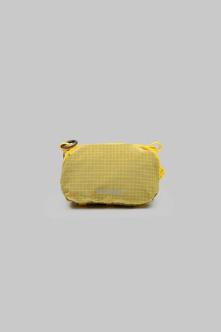 A small yellow sacoche pouch with a grid ripstop material on a light grey background