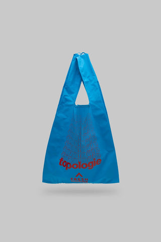 Blue reusable bag with 'topologie' branding on a gray background