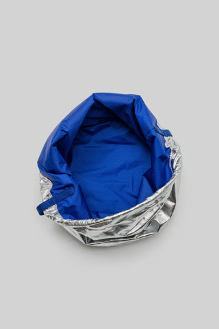 Blue and silver reversible bucket bag on a gray background