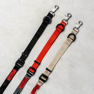 Utility sling straps with metal clips: black, red, and tan with adjustable buckles
