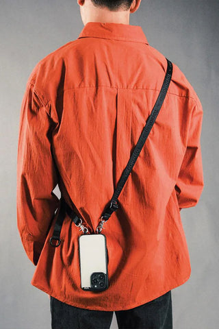 Black utility sling worn crossbody with adjustable strap and front pouch