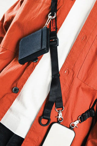 Close-up of black utility sling pouch with strap adjuster and D-ring clips