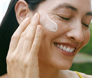 Person applying ursa major serum and smiling 