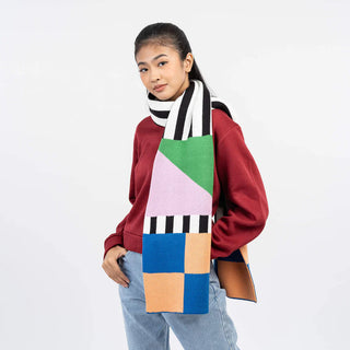Person wearing a colorful geometric scarf on a white background