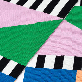 Colorful geometric patterned fabric with pink, green, blue, and black colors.