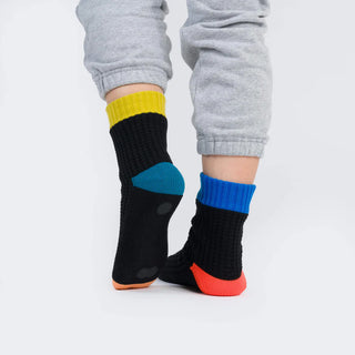 Colorful socks worn with gray pants on a white background