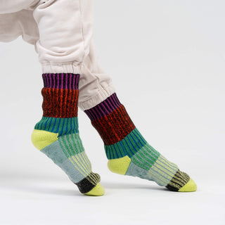 Colorful striped socks worn by a person on a white background